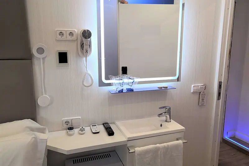 Lavabo integrado en la habitación con espejo iluminado y secador